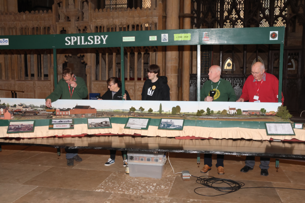 Some of the group with visitors learning to operate the layout